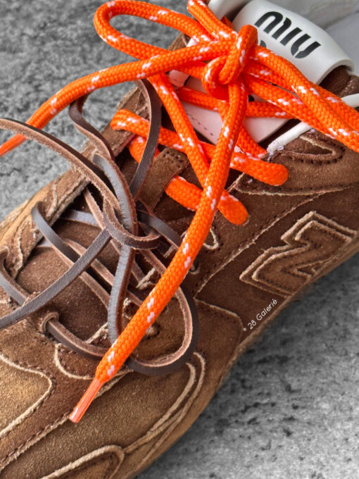 Miu Miu x New Balance 530 SL sneakers in cinnamon suede leather, merging sporty design with luxury craftsmanship.