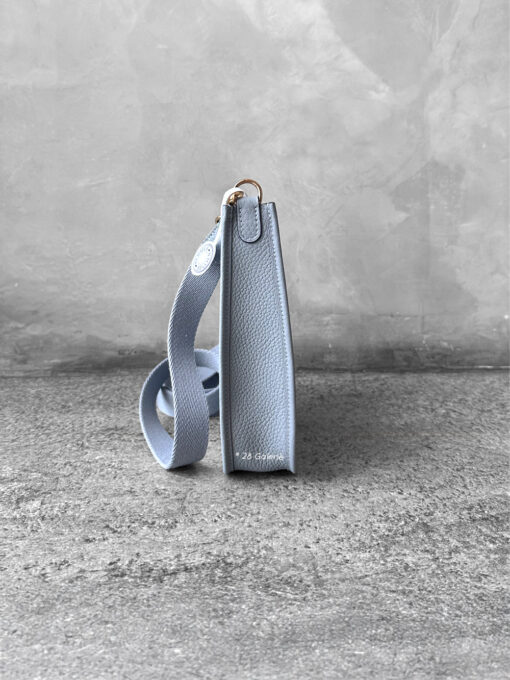 Hermès Bleu Glacier Evelyne 16 Amazone Bag, a compact crossbody in Clemence leather with signature perforated H logo and canvas strap.