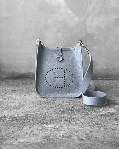 Hermès Bleu Glacier Evelyne 16 Amazone Bag, a compact crossbody in Clemence leather with signature perforated H logo and canvas strap.