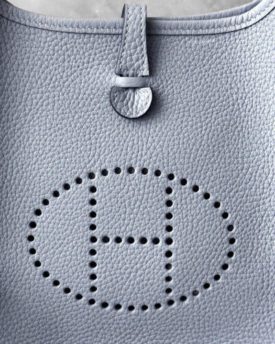 Hermès Bleu Glacier Evelyne 16 Amazone Bag, a compact crossbody in Clemence leather with signature perforated H logo and canvas strap.