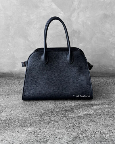The Row Black Soft Margaux Top-handle bag in matte grained calfskin leather with belted gusseted side panels and interior toggle closure